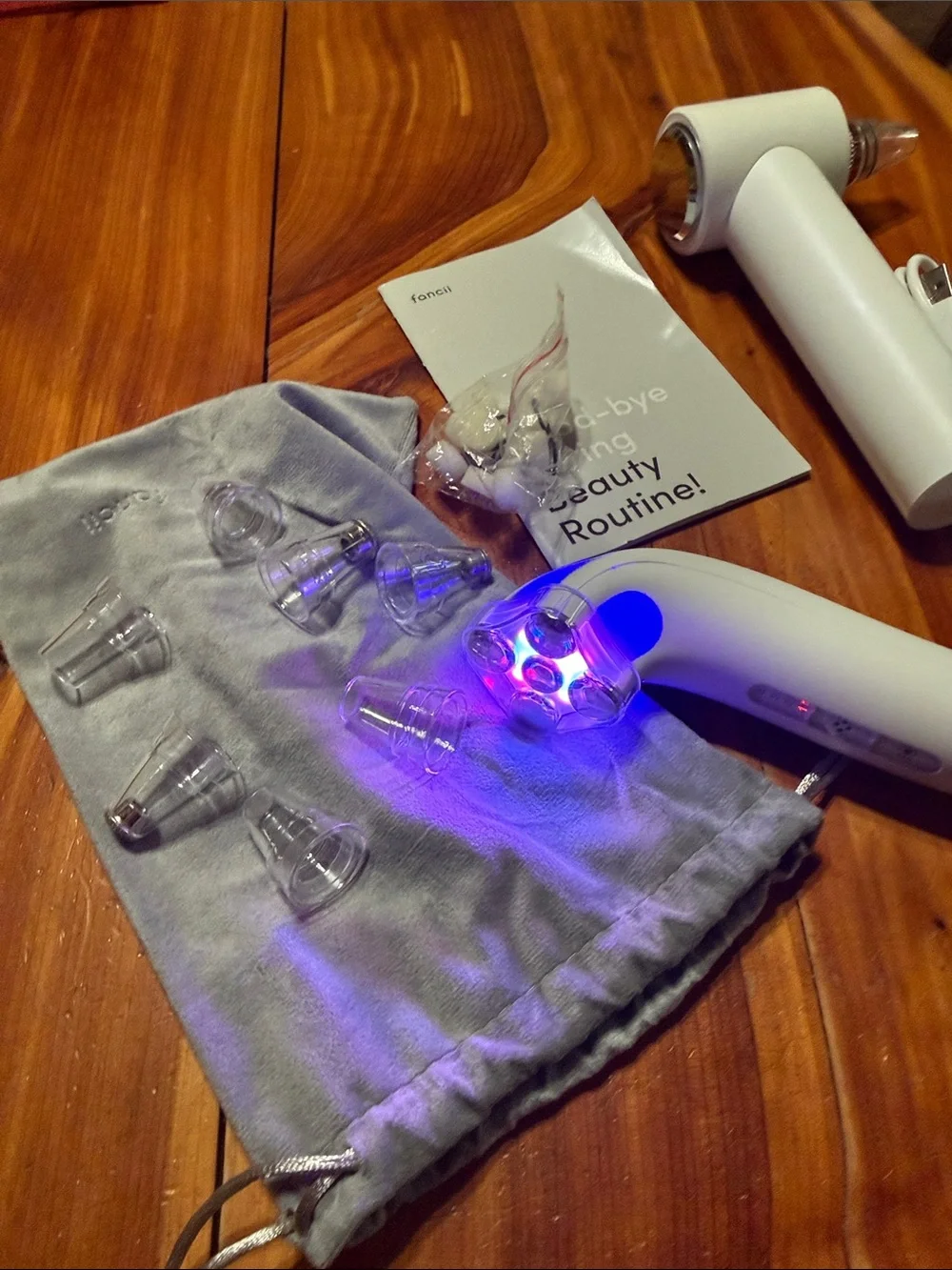 Fancii White & Rose Gold Facial Pore Vacuum and light therapy tool.
